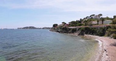 Ferrat Burnu, göl kenarındaki toprak seti, arka planda dağlar ve mavi gökyüzü, dünyanın her yerinden milyarderlerin megayachtları, Güney Fransa, 4k video.