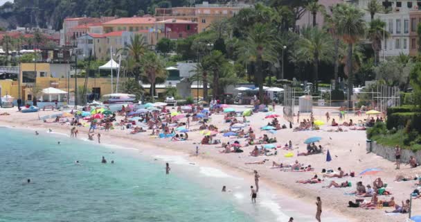 法国，Saint-Jean-Cap-Ferrat，2017年5月29日：披风海岸，海滩上的家庭，洗澡者，孩子们在玩耍，养恤金领取者，度假者，夫妇，日光浴者，打排球，旺季 — 图库视频影像