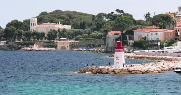 France, Saint-Jean-Cap-Ferrat, 29 травня 2017: Маяк в порту, мега яхти знаходяться на водному горизонті, блакитна вода, багато рибальських човнів і яхт, пірс, пляж Палома. — стокове відео