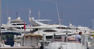 Fransa, Port Saint-Jean-Cap-Ferrat, 29 Mayıs 2017: Yaşlı çift arka planda güneşli bir hava olan yatı, bir iskeleyi, bir megayacht 'ı park ediyor