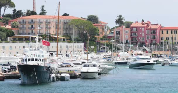 Francia, Saint-Jean-Cap-Ferrat, 29 maggio 2017: Il faro nel porto, mega yacht all'orizzonte, acqua azzurra, un sacco di barche da pesca e yacht, un molo, spiaggia di Paloma — Video Stock