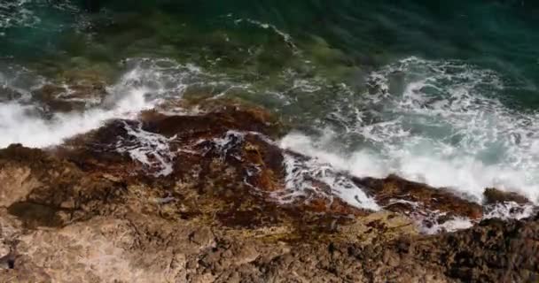 海浪在岩石的岩脉、法国南部的费拉角、蓝色海岸的堤岸、高山和蓝天的衬托下破浪而出, — 图库视频影像