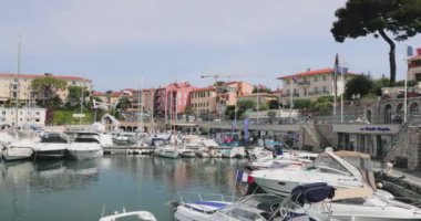 Fransa, Beaulieu, 29 Mayıs 2017: Port Saint-Jean-Cap-Ferrat, bir dükkan ve restoranı olan ünlü gezinti alanı, arka planda birçok turist, villa, otel ve dağ, küçük botlar