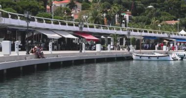 Fransa, Beaulieu, 29 Mayıs 2017: Port Saint-Jean-Cap-Ferrat, bir dükkan ve restoranı olan ünlü gezinti alanı, arka planda birçok turist, villa, otel ve dağ, küçük botlar