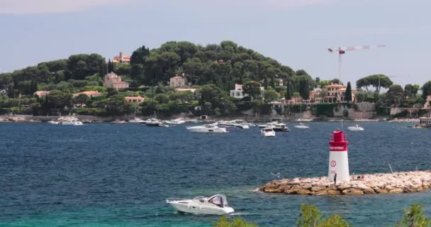 France, Saint-Jean-Cap-Ferrat, 29 mai 2017 : Le phare dans le port, méga yachts sont à l'horizon de l'eau, eau azur, beaucoup de bateaux de pêche et de yachts, une jetée, plage de Paloma — Video