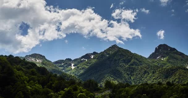 Czas-upływ chmur nad górami w Krasnodarze, Krasnaya Polyana, Soczi, Rosja, przejrzysta słoneczna pogoda, chmury unoszą się na zielonych górach, pozostawiając pod sobą cienie, szczyty gór — Wideo stockowe