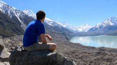 Kayada oturan adam Tasman Buzulu, Yeni Zelanda 'ya bakıyor..