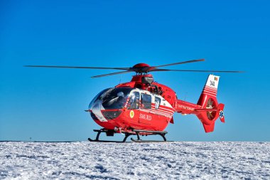 Ceaahlau, ROMANIA - 09 February 2019:SMURD helicopter on mission on the top of the Ceahlau mountains(Romanian Emergency Rescue Service) clipart