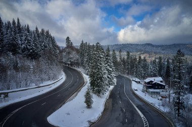 Predeal dağ yolunda kış mevsiminde karla kaplı bir yılanın insansız hava aracı görüntüsü, Romanya 'nın Predeal kentinde