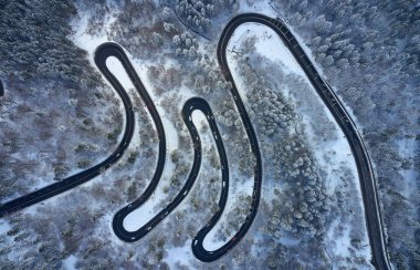 Predeal dağ yolunda kış mevsiminde karla kaplı bir yılanın insansız hava aracı görüntüsü, Romanya 'nın Predeal kentinde