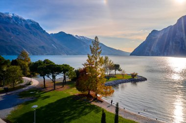 Riva del Garda 'da güzel ve renkli bir sonbahar, muhteşem Garda Gölü' nün panoraması sonbahar zamanı dağlarla çevrili.