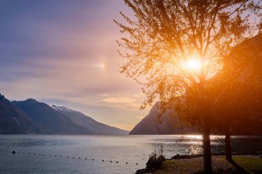Riva del Garda 'da güzel ve renkli bir sonbahar, muhteşem Garda Gölü' nün panoraması sonbahar zamanı dağlarla çevrili.