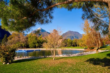 Riva del Garda 'da güzel ve renkli bir sonbahar, muhteşem Garda Gölü' nün panoraması sonbahar zamanı dağlarla çevrili.