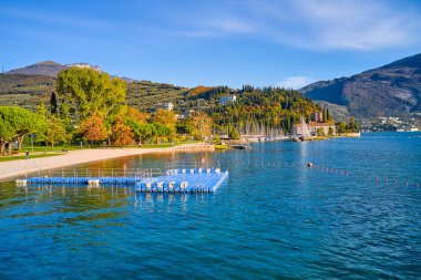 Riva del Garda 'da güzel ve renkli bir sonbahar, muhteşem Garda Gölü' nün panoraması sonbahar zamanı dağlarla çevrili.
