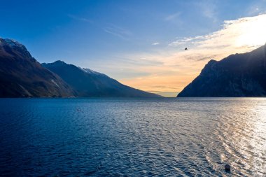Riva del Garda 'da güzel ve renkli bir sonbahar, muhteşem Garda Gölü' nün panoraması sonbahar zamanı dağlarla çevrili.