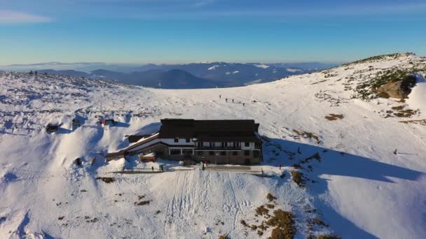Chata Dochia i szczyt Toaca o wschodzie słońca w górach Ceahlău National w sezonie zimowym, Widok z lotu ptaka na zimę — Wideo stockowe