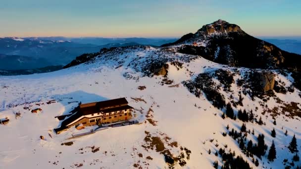 Dochia chalet y pico de Toaca al amanecer en las montañas Ceahljalá Nacional en temporada de invierno, Invierno aéreo Vista del paisaje desde el dron — Vídeo de stock