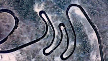Predeal dağ yolunda kış mevsiminde karla kaplı bir yılanın insansız hava aracı görüntüsü, Romanya 'nın Predeal kentinde