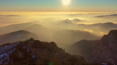 Kış mevsiminde bulutlar denizi, kış mevsiminde sis, Ceahlau Dağları 'nda güneş doğarken Ceahlthe Dağları Ulusal Parkı' ndan hava manzarası. İHA 'dan hava görüntüsü