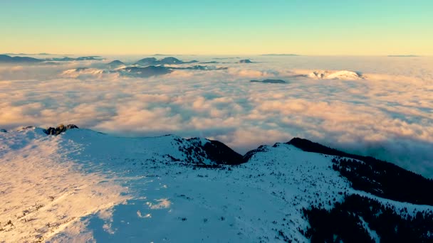 Kış mevsiminde bulutlar denizi, kış mevsiminde sis, Ceahlau Dağları 'nda güneş doğarken Ceahlthe Dağları Ulusal Parkı' ndan hava manzarası. İHA 'dan hava görüntüsü — Stok video