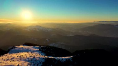 Kışın günbatımında Ceahlau Dağları Ulusal Parkı ve Toaca Zirvesi 'nden hava manzarası. İHA 'dan hava görüntüsü