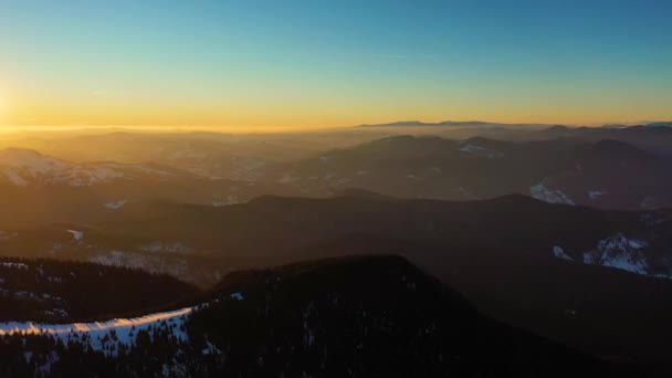 Letecký výhled na krajinu z Národního parku Ceahlau a vrcholu Toaca při západu slunce v zimním období. Letecký pohled z dronu — Stock video