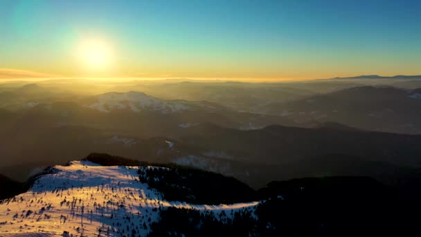 Vista aérea da paisagem do Parque Nacional das Montanhas Ceahlau e pico de Toaca ao pôr-do-sol na temporada de inverno. Vista aérea do drone — Vídeo de Stock