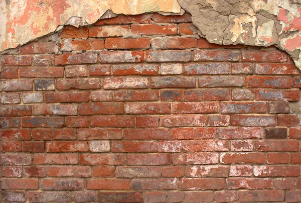 An average plan of an old red weathered brick wall with cement remains