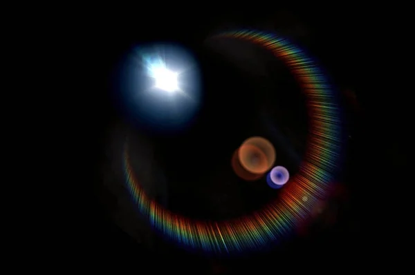 Πολύχρωμο φως φωτοβολίδα φακού σε μαύρο φόντο. Εικόνα Αρχείου