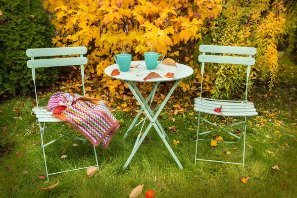 Colorido canto do jardim de outono com chá quente e cobertor — Fotografia de Stock