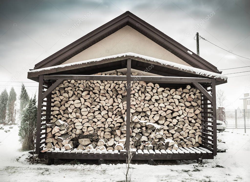 Winter - woodshed filled with birch firewood
