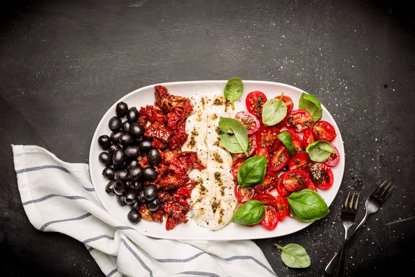 Hidangan pembuka Italia - mozzarella, tomat, zaitun dan kemangi — Stok Foto