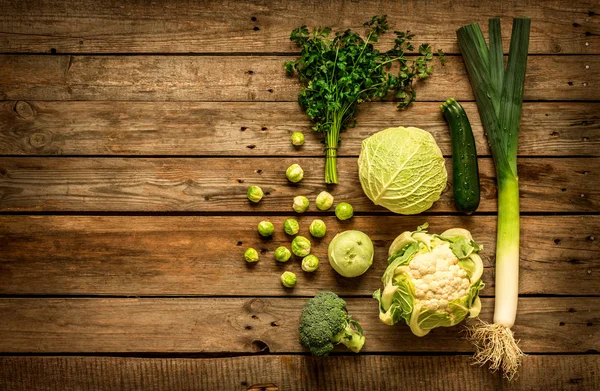 ビンテージの素朴な木製の背景に緑の野菜 — ストック写真
