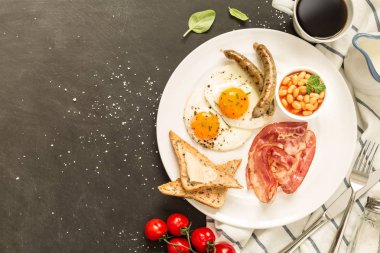 Tam İngiliz kahvaltısı beyaz tabak, siyah arka plan üzerinde.