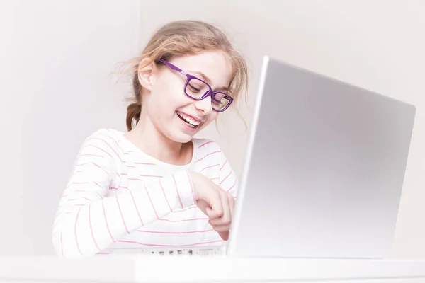 Happy smiling child girl (kid) using laptop computer — Stock Photo, Image