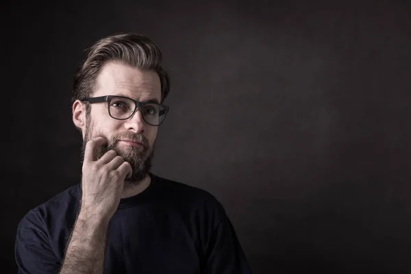 Thoughtful caucasian man in casual t-shirt and glasses — Stock Photo, Image