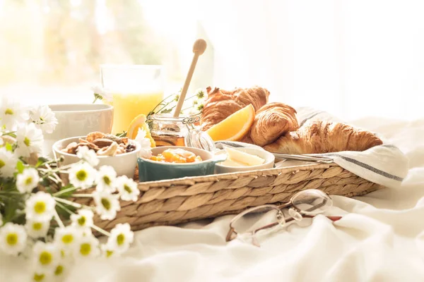 Bandeja de mimbre con desayuno continental en sábanas blancas —  Fotos de Stock