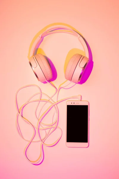 Mobile phone (smartphone) and headphones on pink — Stock Photo, Image