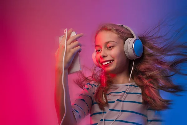 Girl with smartphone and headphones listens to music — Stock Photo, Image