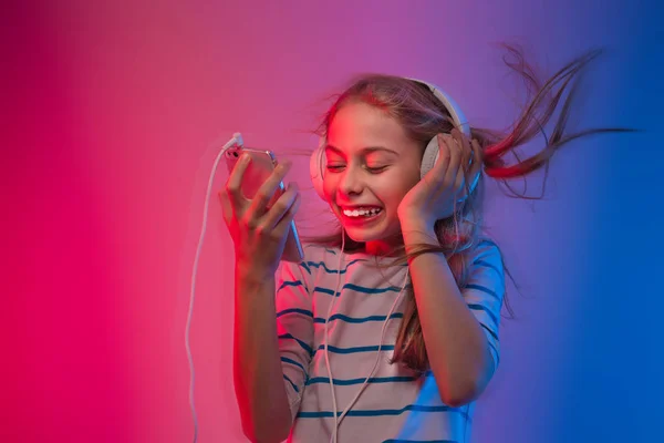 Girl with smartphone and headphones listens to music — Stock Photo, Image