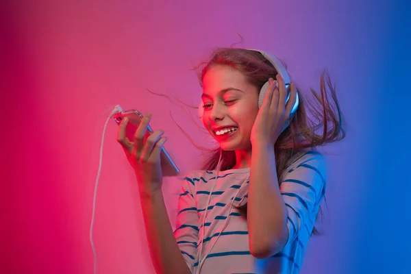 Girl with smartphone and headphones listens to music — Stock Photo, Image