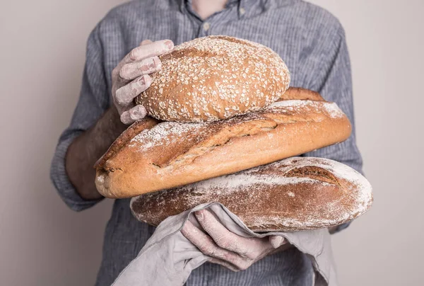 Pile de pains rustiques croustillants dans les mains du boulanger — Photo