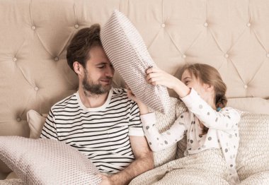 Baba ve kızı yastık sahip bir yatakta mücadele