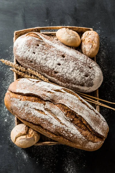 Хлібобулочні вироби - сільський хліб хліба та булочок на чорному — стокове фото