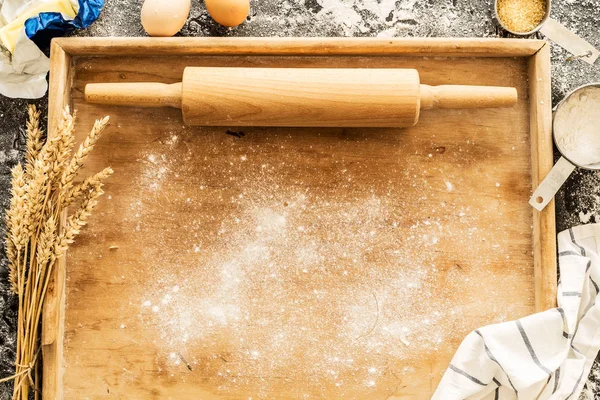 Rolling pin on pastry board and food ingredients - kitchen