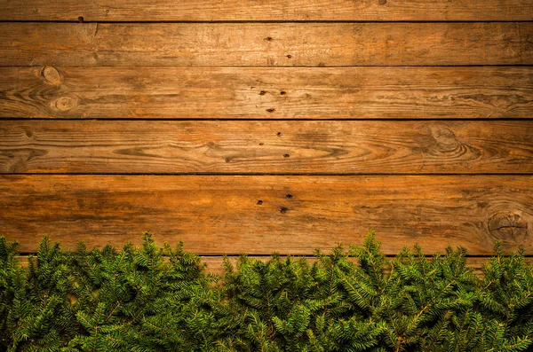 Дерев'яний різдвяний фон з зеленими гілками сосни — стокове фото