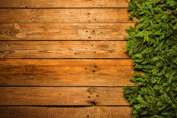 Holz Weihnachten Hintergrund mit grünen Tannenzweigen — Stockfoto