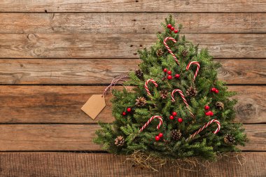 Ahşap arka planda süslemeleri olan Noel ağacı