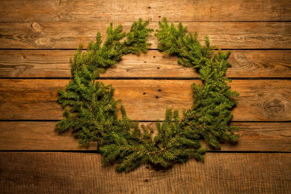 Couronne de Noël en branches de pin vert naturel sur bois — Photo