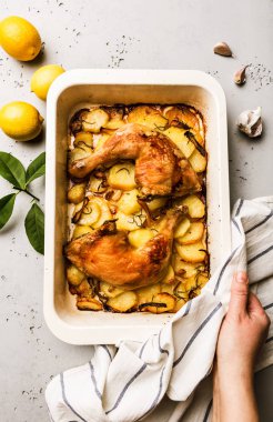 Fırınlanmış tavuk budu ve patates dilimleri.